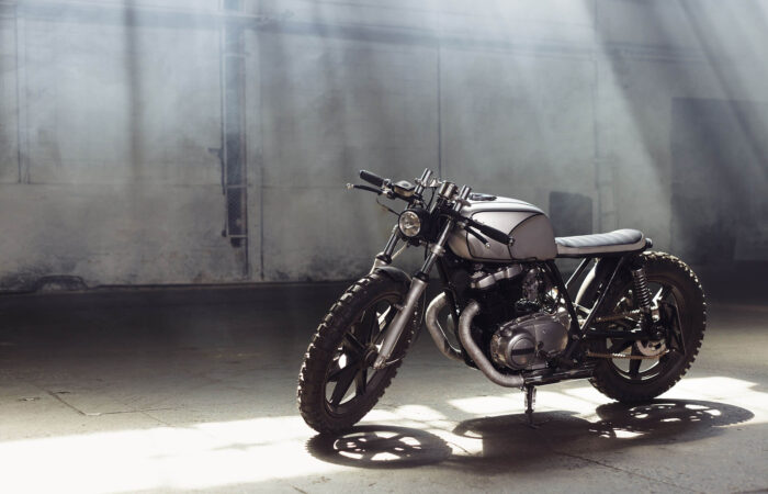 motorcycle-standing-in-dark-building-in-rays-of-su-PGGG49F